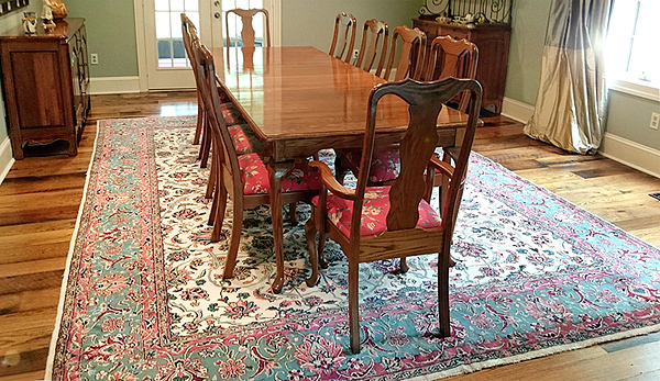 Dining room setting features antique carpet from Nejad