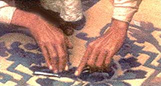 Photo depicting the process of incising a design into the surface of the rug.